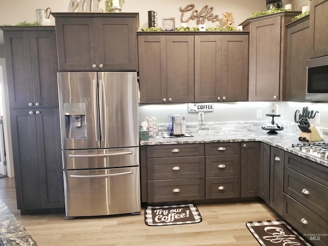 3847 N 2456 E, Filer, ID 83328 - kitchen featuring dark brown cabinets, stainless steel appliances, light stone counters, and light wood-type flooring