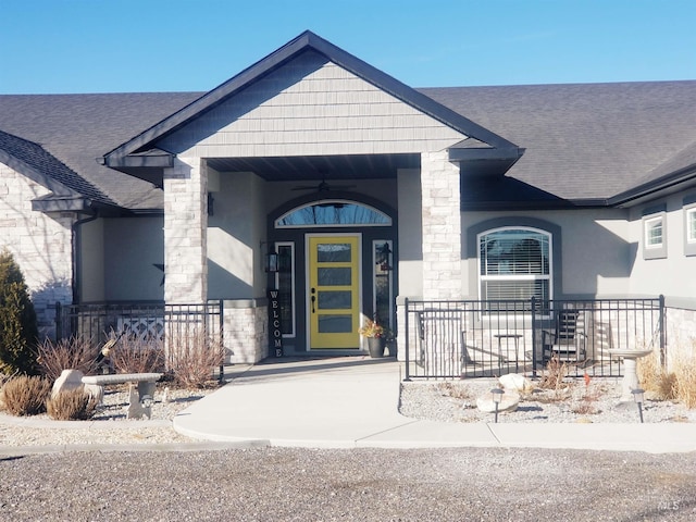 3847 N 2456 E, Filer, ID 83328 - view of exterior entry with stone siding, a porch, stucco siding, and roof with shingles