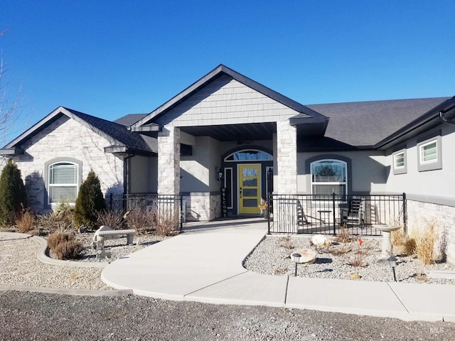 3847 N 2456 E, Filer, ID 83328 - view of front of home with stone siding, roof with shingles, a porch, and stucco siding