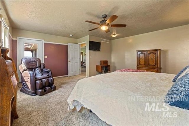 carpeted bedroom with a ceiling fan, visible vents, and a textured ceiling