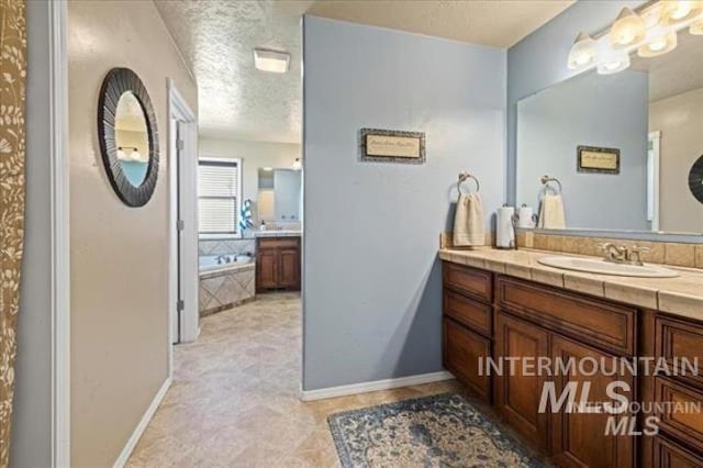 bathroom featuring a textured ceiling, vanity, and baseboards