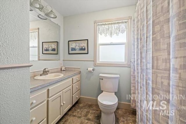 full bath with toilet, a shower with curtain, baseboards, and vanity