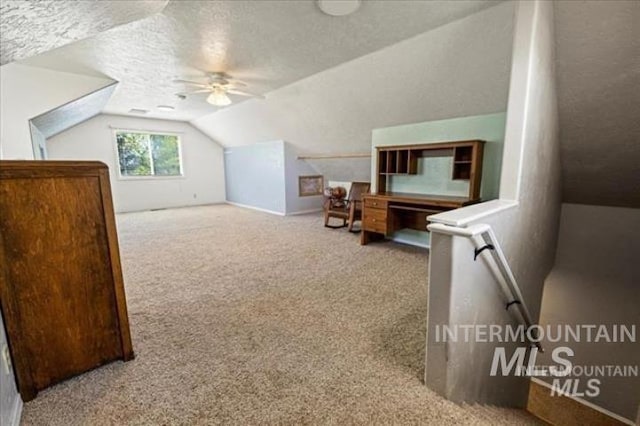 additional living space with carpet, ceiling fan, lofted ceiling, and a textured ceiling