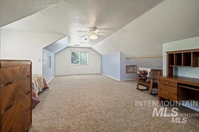 bedroom with carpet, a ceiling fan, vaulted ceiling, a textured ceiling, and baseboards