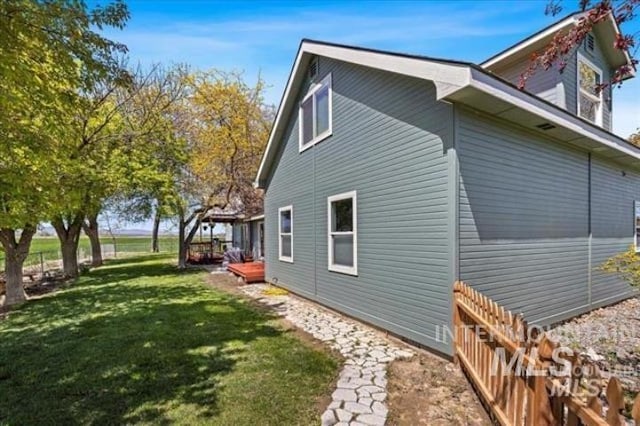 view of side of property featuring a yard and fence