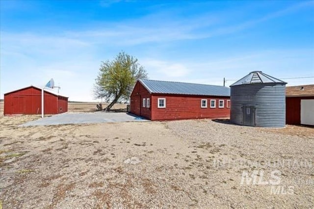 exterior space featuring metal roof and an outbuilding