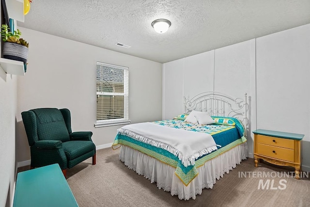 carpeted bedroom featuring a textured ceiling