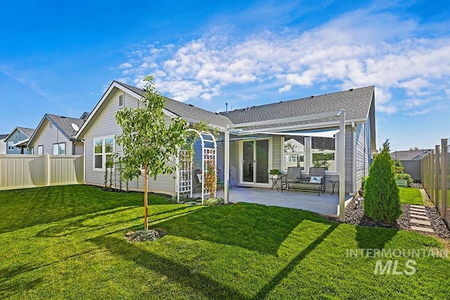 rear view of property with a lawn and a patio area