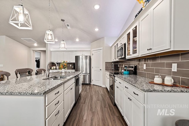 kitchen featuring appliances with stainless steel finishes, an island with sink, white cabinetry, and sink