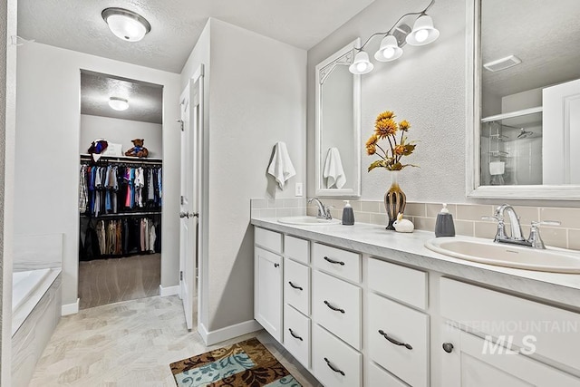 bathroom featuring vanity, independent shower and bath, and a textured ceiling