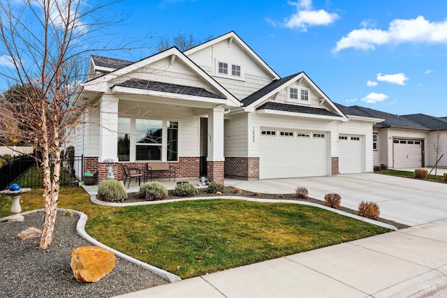 craftsman-style home with covered porch, a garage, and a front lawn