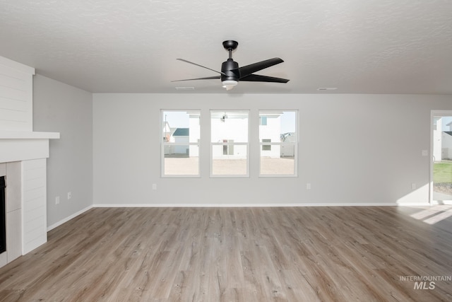 unfurnished living room featuring ceiling fan, a textured ceiling, and light wood-type flooring