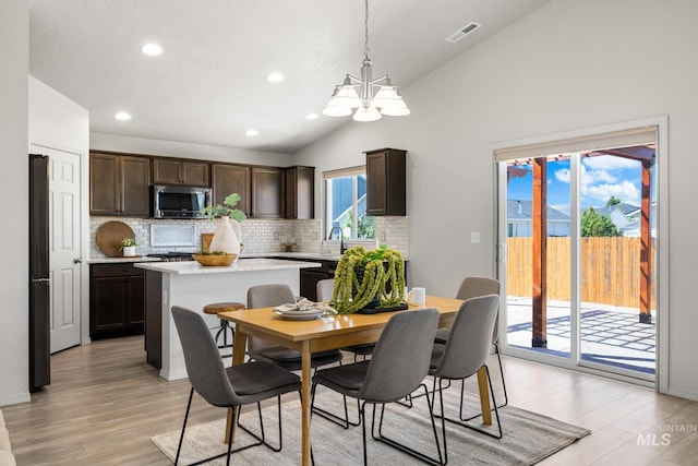12850 Conner St, Caldwell, ID 83607 - dining space with vaulted ceiling, a chandelier, recessed lighting, and light wood finished floors
