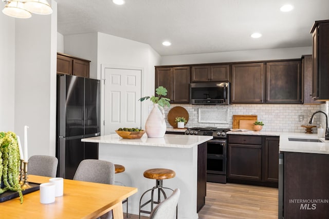 12850 Conner St, Caldwell, ID 83607 - kitchen featuring appliances with stainless steel finishes, dark brown cabinets, a sink, light wood-type flooring, and recessed lighting