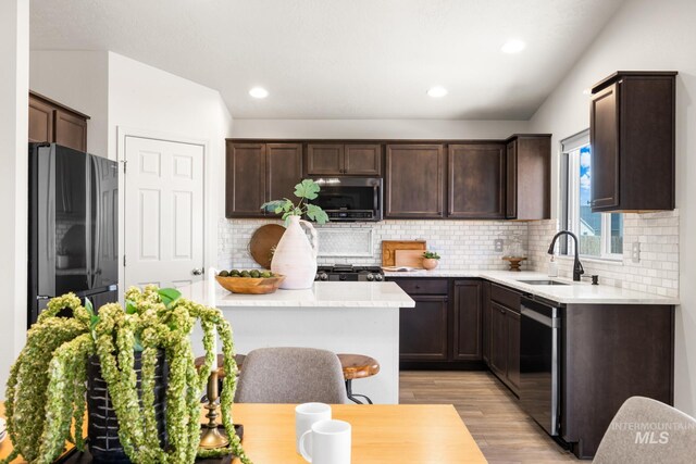 12850 Conner St, Caldwell, ID 83607 - kitchen featuring appliances with stainless steel finishes, a sink, dark brown cabinetry, light wood-style floors, and light countertops