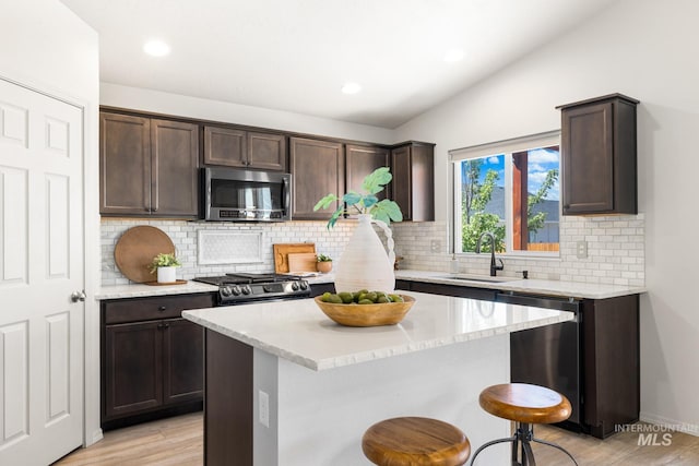 12850 Conner St, Caldwell, ID 83607 - kitchen featuring stainless steel appliances, dark brown cabinetry, light wood-type flooring, a sink, and lofted ceiling