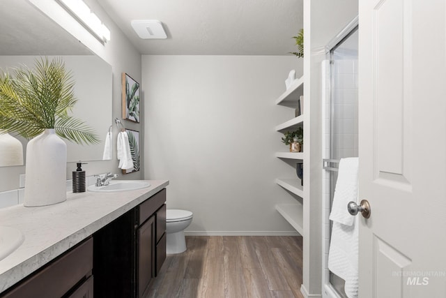 12850 Conner St, Caldwell, ID 83607 - full bath with wood finished floors, double vanity, toilet, baseboards, and a shower