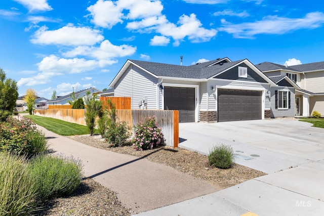 12850 Conner St, Caldwell, ID 83607 - view of side of home featuring a garage, concrete driveway, and stone siding