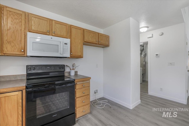 1471 Wrangler St, Twin Falls, ID 83301 - kitchen with white microwave, black electric range oven, light wood-type flooring, baseboards, and a textured ceiling