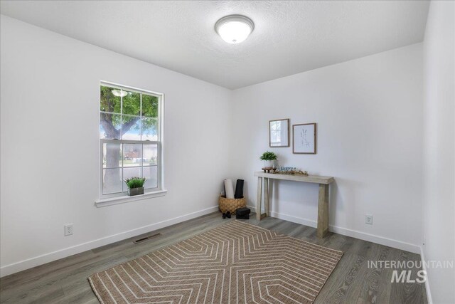 1471 Wrangler St, Twin Falls, ID 83301 - unfurnished office with wood finished floors, baseboards, and a textured ceiling