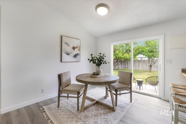 1471 Wrangler St, Twin Falls, ID 83301 - dining area with light wood-style floors, lofted ceiling, a textured ceiling, and baseboards