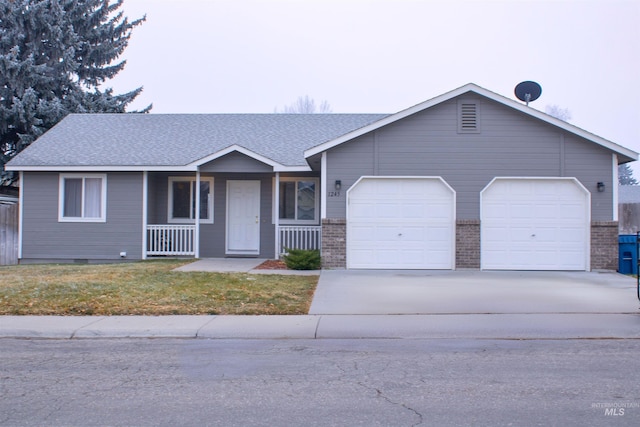 single story home with a garage, covered porch, and a front lawn