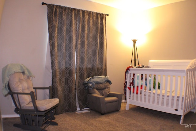 carpeted bedroom featuring a nursery area