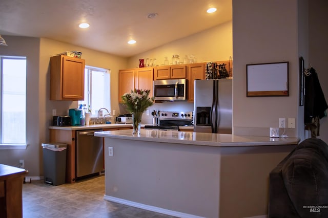 kitchen featuring kitchen peninsula, sink, stainless steel appliances, and lofted ceiling