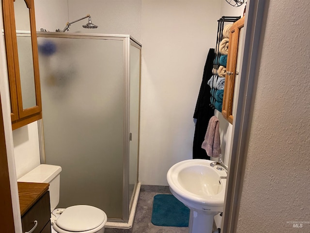 bathroom with tile patterned floors, sink, an enclosed shower, and toilet