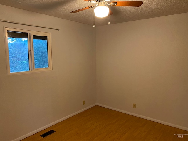 unfurnished room with ceiling fan, hardwood / wood-style flooring, and a textured ceiling