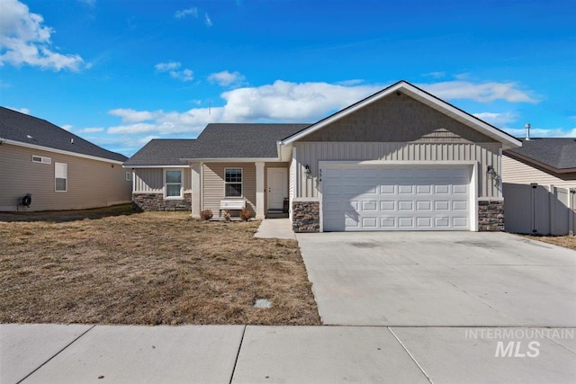 single story home with a garage, fence, stone siding, concrete driveway, and board and batten siding