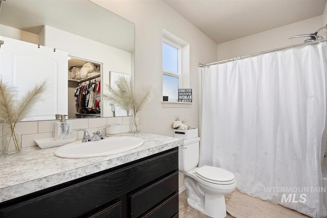 bathroom featuring a shower with curtain, vanity, and toilet