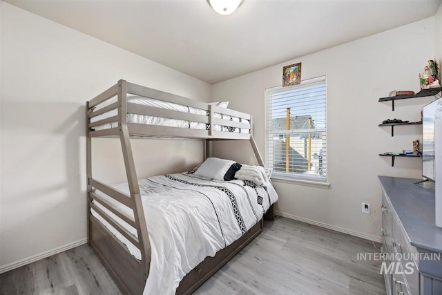 bedroom with light wood-style flooring and baseboards