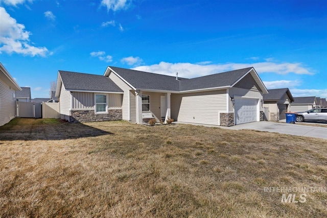 ranch-style house featuring a garage, driveway, stone siding, fence, and a front yard