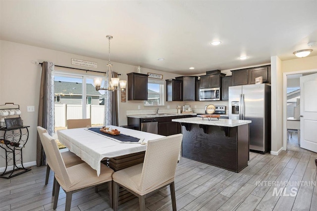 dining area with recessed lighting, plenty of natural light, light wood-style flooring, and baseboards