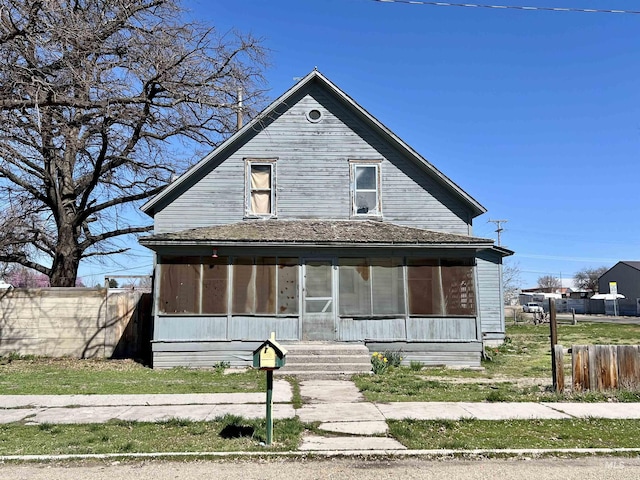 view of front of house with a sunroom and fence