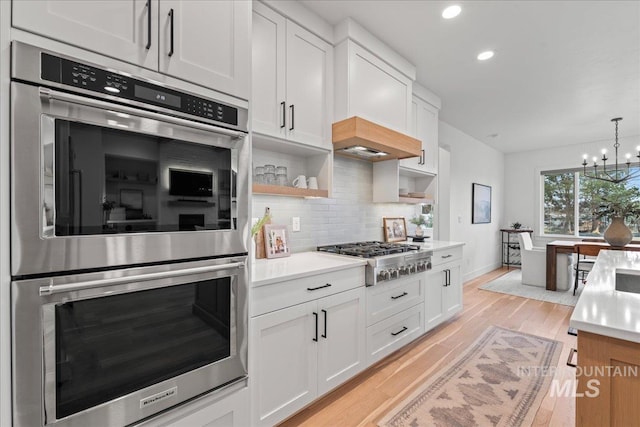 kitchen with tasteful backsplash, white cabinets, appliances with stainless steel finishes, light countertops, and open shelves