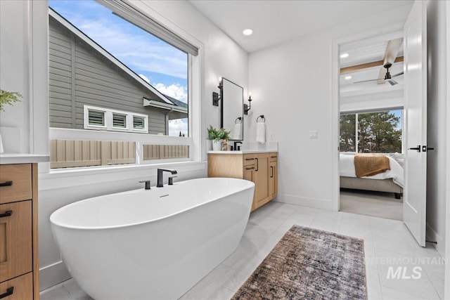 ensuite bathroom with recessed lighting, a freestanding bath, connected bathroom, vanity, and tile patterned flooring