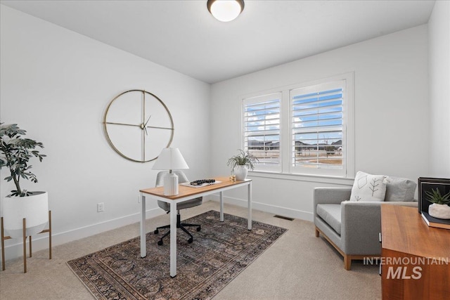 home office featuring light colored carpet, visible vents, and baseboards