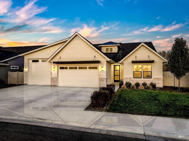 view of front facade with an attached garage, driveway, fence, and a front yard