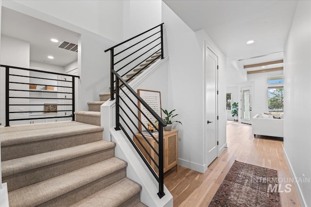 staircase with recessed lighting, visible vents, baseboards, and wood finished floors