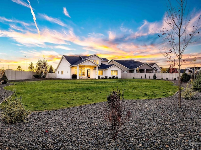 modern inspired farmhouse featuring a lawn and a fenced backyard