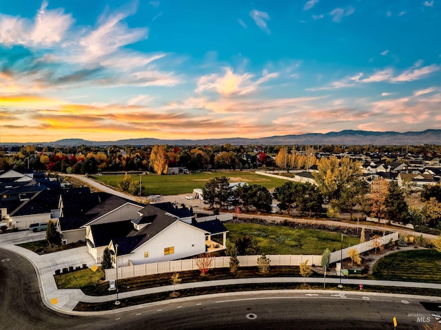 aerial view at dusk featuring a residential view and a mountain view