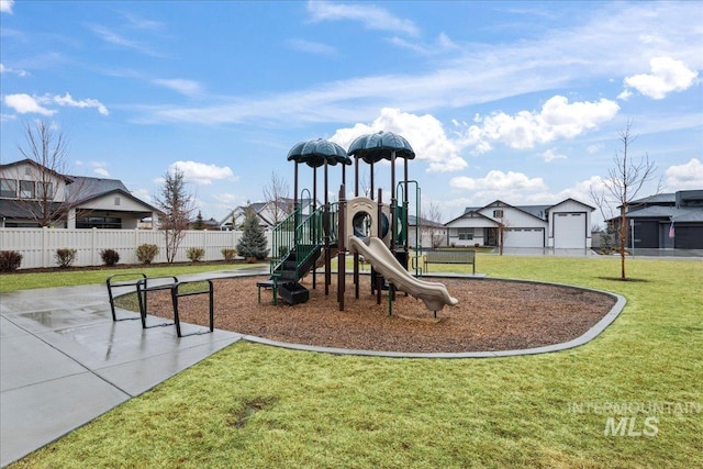 communal playground featuring a lawn and fence