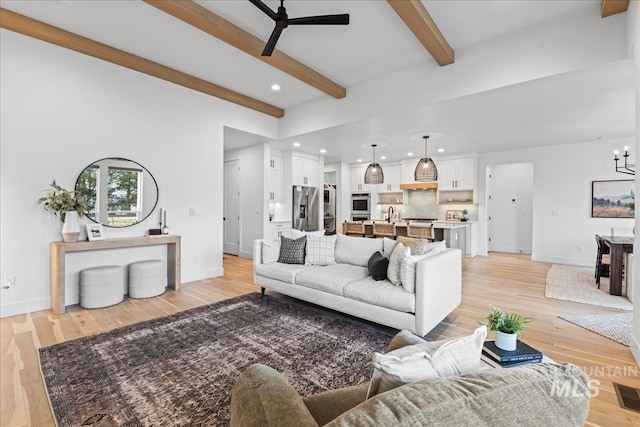 living room featuring baseboards, beamed ceiling, ceiling fan with notable chandelier, light wood-type flooring, and recessed lighting