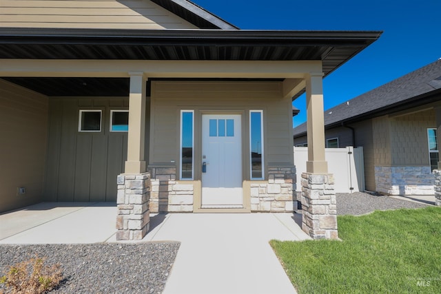 doorway to property featuring stone siding and board and batten siding