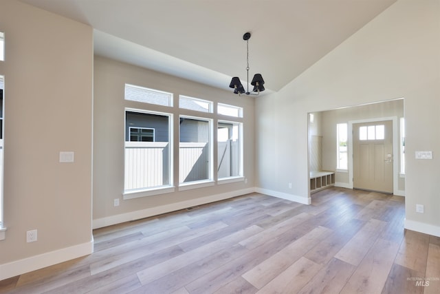 534 Falling Leaf Ln, Twin Falls, ID 83301 - unfurnished dining area featuring a chandelier, light wood-style floors, baseboards, and high vaulted ceiling