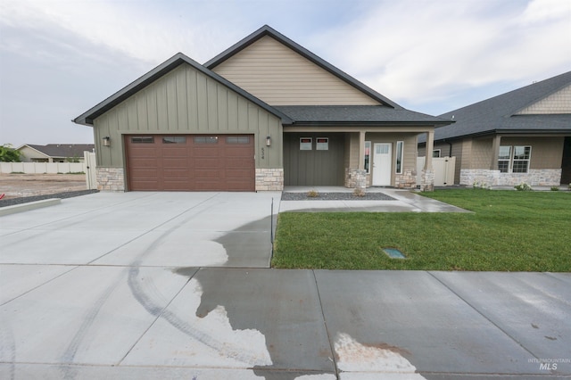 view of front of house featuring an attached garage, stone siding, concrete driveway, board and batten siding, and a front yard