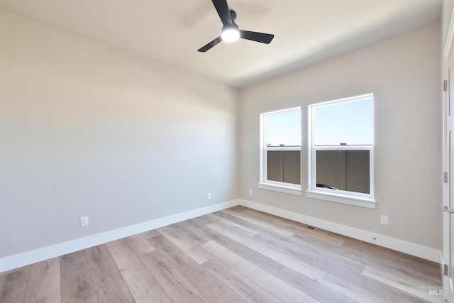 spare room with baseboards, visible vents, and light wood finished floors