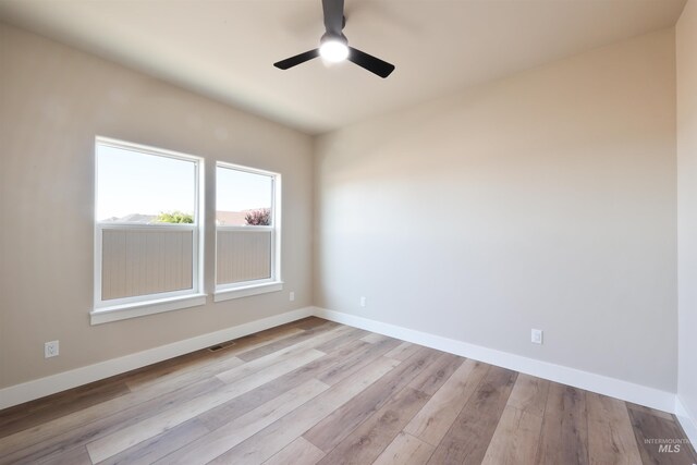 unfurnished room featuring baseboards, visible vents, a ceiling fan, and light wood-style floors